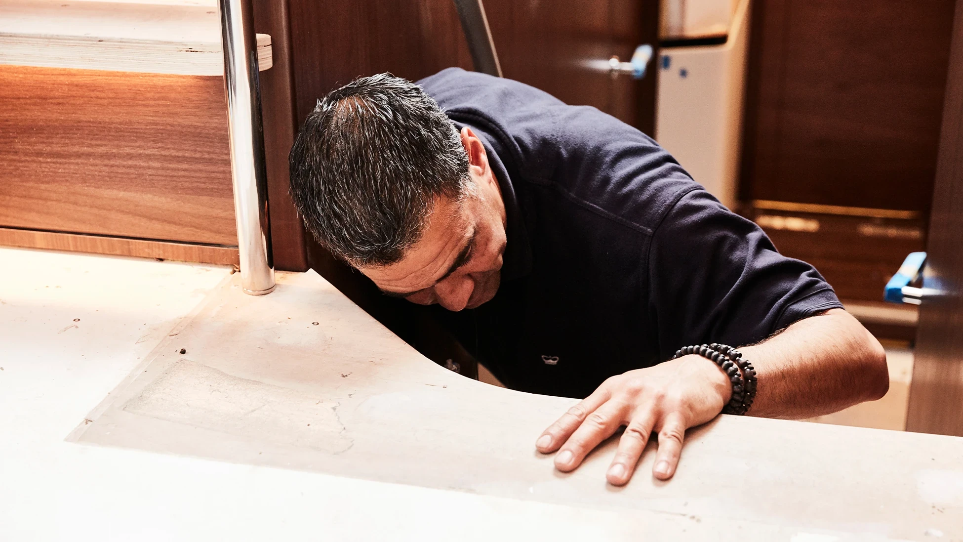 Een vakman werkt nauwkeurig aan het interieur van een Princess-jacht, waarbij hij oog heeft voor detail en vakmanschap.